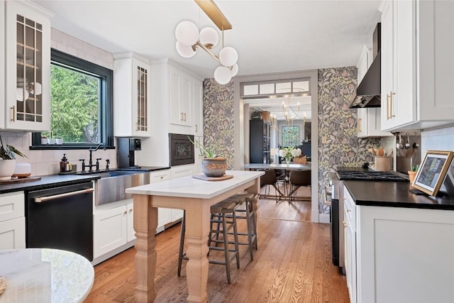 kitchen featuring pendant lighting, dishwasher, white cabinetry, a notable chandelier, and stainless steel range with gas cooktop