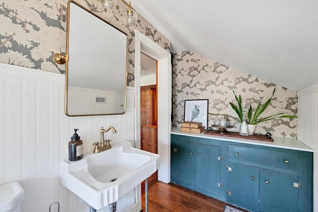 bathroom with vaulted ceiling, sink, and hardwood / wood-style floors