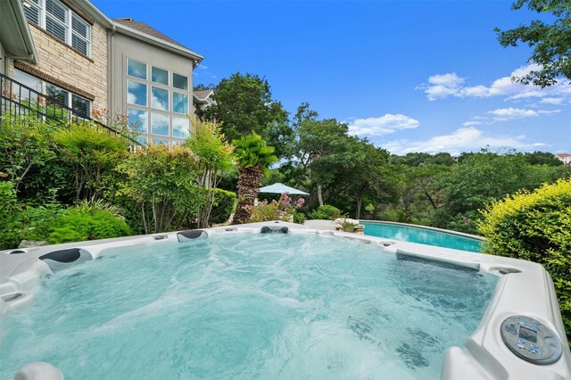 view of swimming pool featuring a hot tub