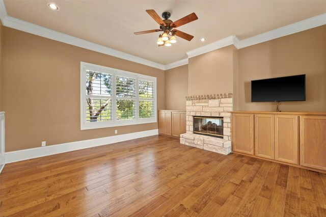 unfurnished living room featuring crown molding, ceiling fan, a fireplace, and light hardwood / wood-style floors