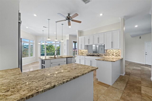 kitchen featuring white cabinetry, hanging light fixtures, a kitchen island, stainless steel dishwasher, and kitchen peninsula