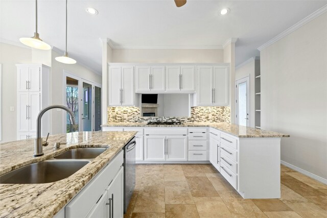 kitchen with pendant lighting, sink, white cabinetry, decorative backsplash, and stainless steel dishwasher