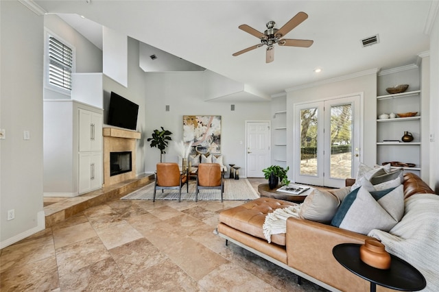 living room featuring baseboards, visible vents, built in features, ceiling fan, and a high end fireplace