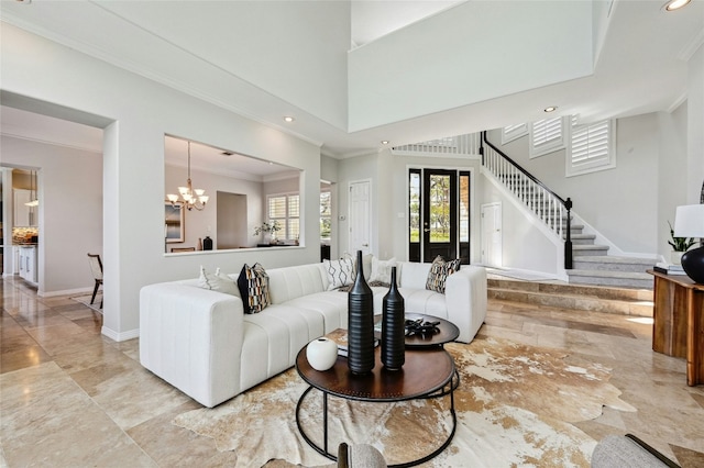 living area with baseboards, ornamental molding, a high ceiling, stairs, and a chandelier