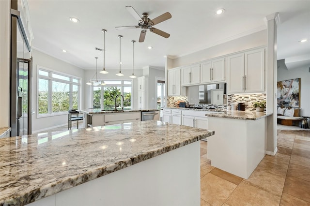 kitchen with stainless steel appliances, a peninsula, a sink, and white cabinetry