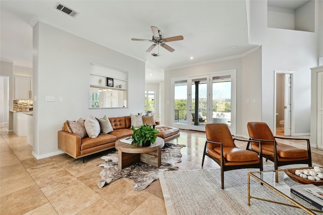 living area featuring baseboards, ceiling fan, visible vents, and crown molding