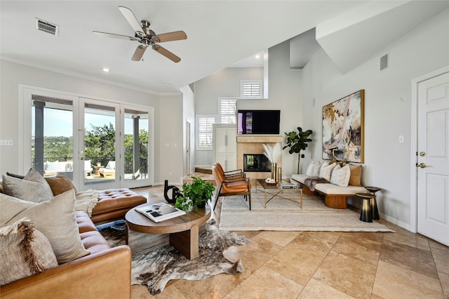 living area with baseboards, visible vents, a tiled fireplace, and ornamental molding