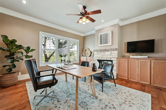 office featuring a stone fireplace, wood finished floors, and crown molding