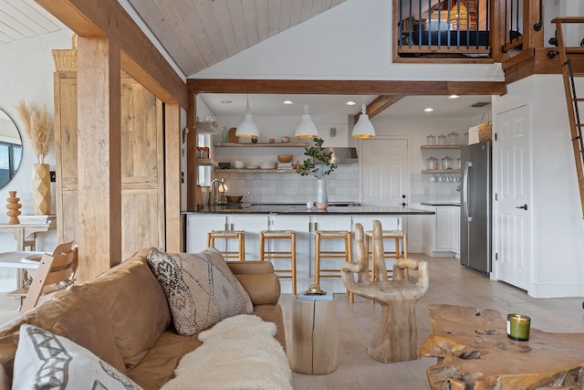 living room featuring vaulted ceiling with beams, wood ceiling, light hardwood / wood-style floors, and sink