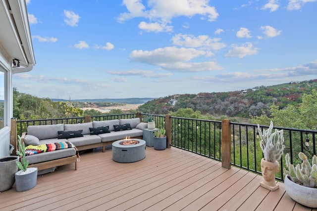 wooden deck featuring an outdoor living space with a fire pit