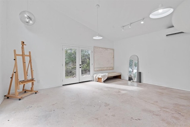 interior space with concrete flooring, an AC wall unit, a wealth of natural light, and french doors