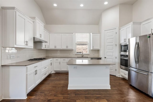 kitchen featuring sink, stainless steel appliances, a center island, white cabinets, and vaulted ceiling