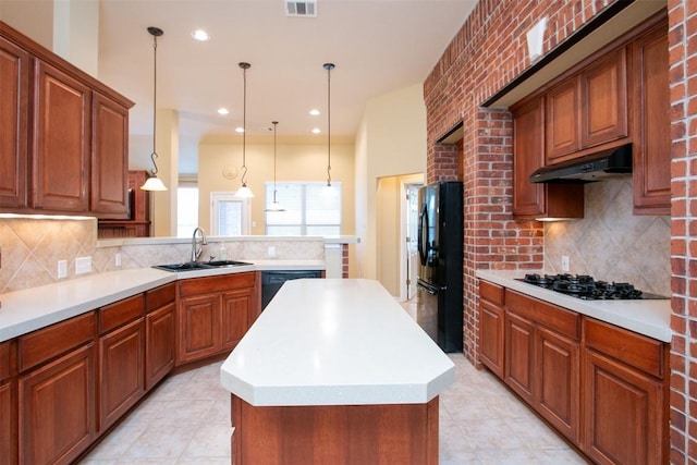 kitchen with pendant lighting, sink, black appliances, a kitchen island, and kitchen peninsula