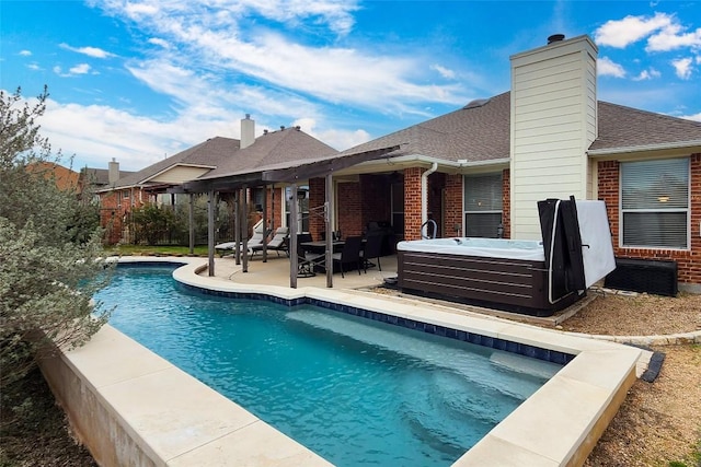 view of pool with a hot tub and a patio