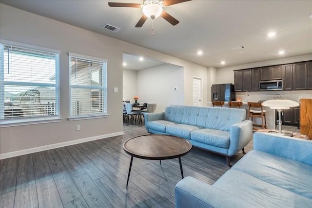 living room with dark hardwood / wood-style flooring and ceiling fan