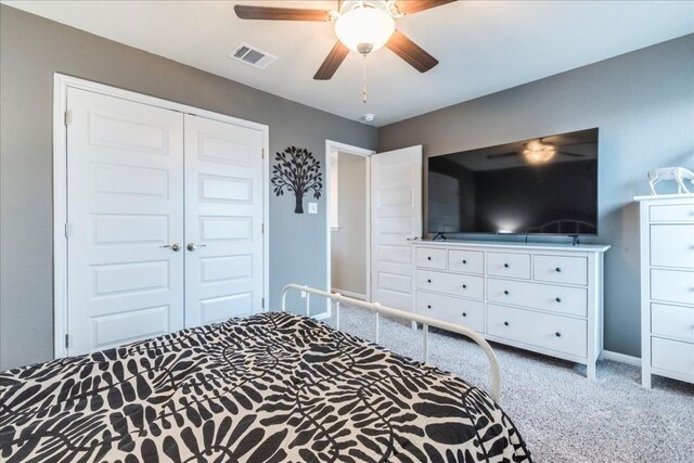 carpeted bedroom with a closet and ceiling fan