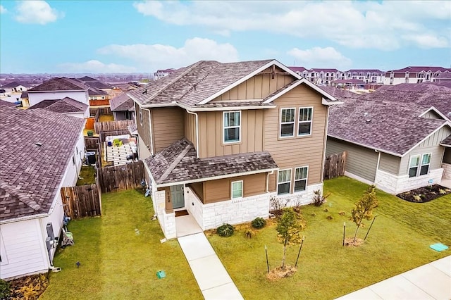 122 Fairmeadow Downs Dr, Hutto, TX 78634 - view of front of home featuring stone siding, a fenced backyard, a front lawn, board and batten siding, and a residential view