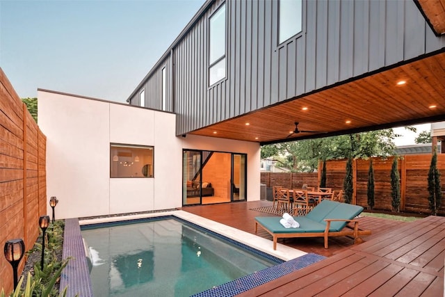 back house at dusk featuring a swimming pool side deck