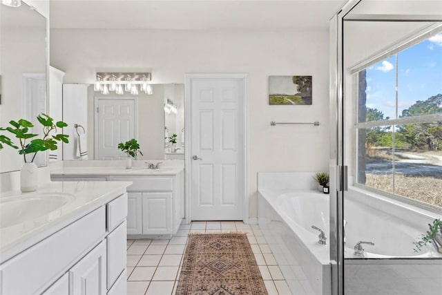 bathroom featuring a relaxing tiled tub, tile patterned floors, and vanity