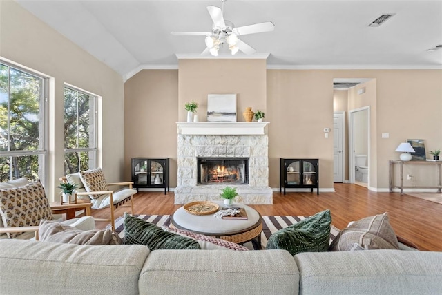 1001 Springlake Dr, Dripping Springs, TX 78620 - living room with wood finished floors, a ceiling fan, a stone fireplace, ornamental molding, and baseboards