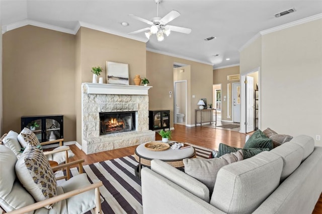 living room featuring crown molding, lofted ceiling, wood-type flooring, and a fireplace