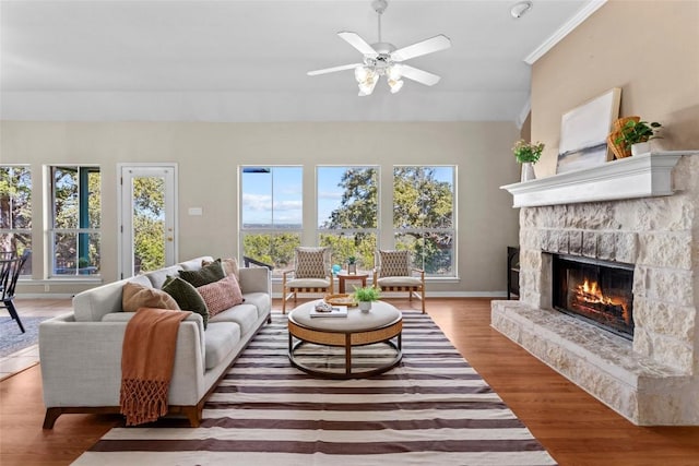1001 Springlake Dr, Dripping Springs, TX 78620 - living area featuring a stone fireplace, wood finished floors, a ceiling fan, vaulted ceiling, and baseboards