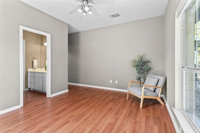 living area featuring light hardwood / wood-style flooring and ceiling fan