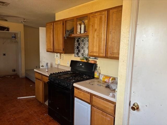 kitchen with dark tile patterned flooring and gas stove