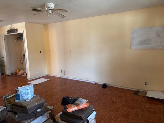 unfurnished living room with dark tile patterned floors and ceiling fan