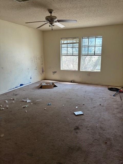 unfurnished room featuring ceiling fan, carpet, and a textured ceiling