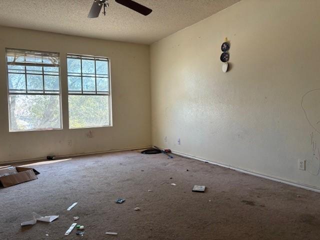 unfurnished room with ceiling fan, carpet flooring, and a textured ceiling