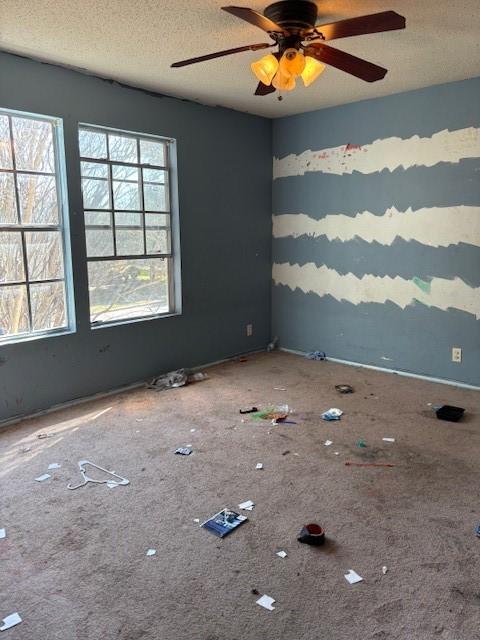 unfurnished room featuring ceiling fan and a textured ceiling