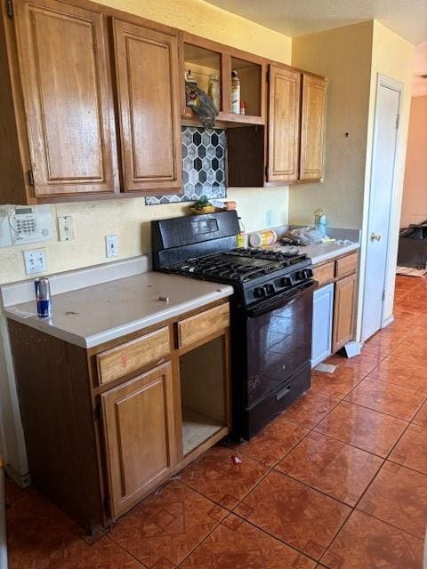 kitchen with gas stove and dark tile patterned floors