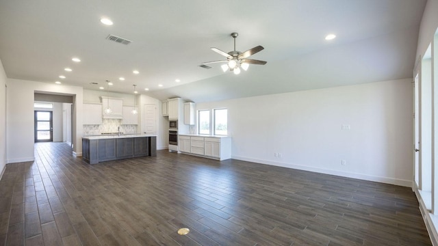 1412 Snowdrop Dr, Georgetown, TX 78628 - unfurnished living room featuring a ceiling fan, vaulted ceiling, dark wood-type flooring, and recessed lighting