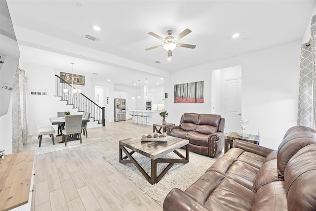 living room with ceiling fan and light hardwood / wood-style floors