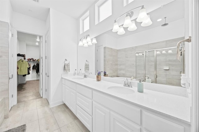 bathroom featuring vanity, a shower with shower door, and tile patterned flooring