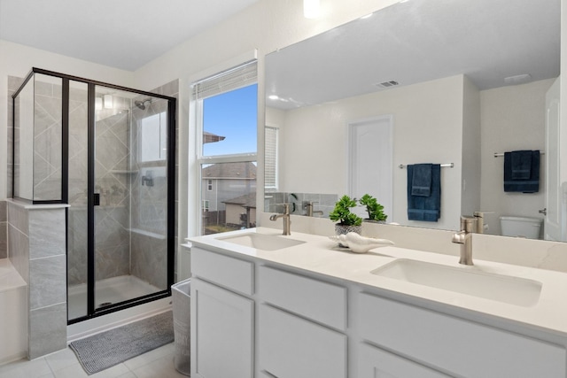 bathroom with vanity, a shower with shower door, tile patterned floors, and toilet