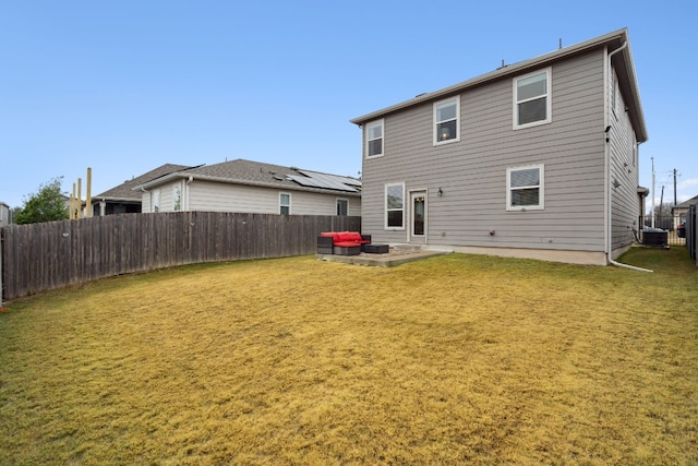 rear view of property with a yard, cooling unit, and a patio area