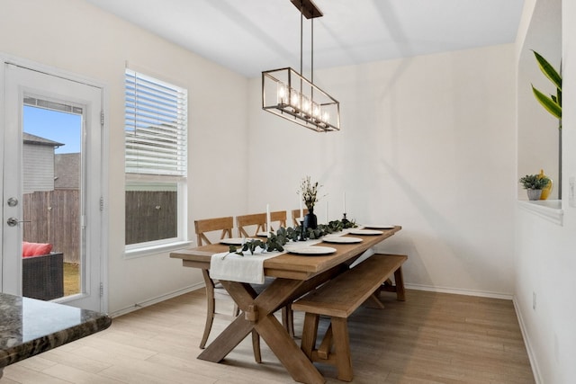 dining space with a chandelier and light wood-type flooring