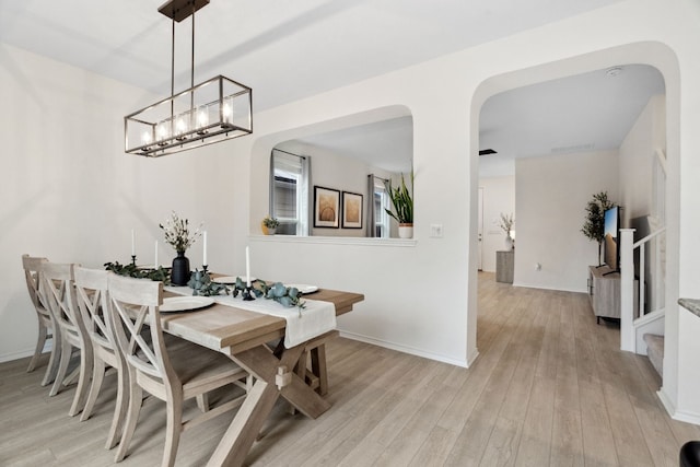 dining space with an inviting chandelier and light wood-type flooring