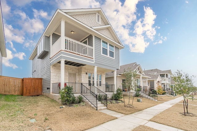 221 Duck Creek Trl, San Marcos, TX 78666 - view of front facade featuring a balcony, covered porch, stone siding, and a residential view