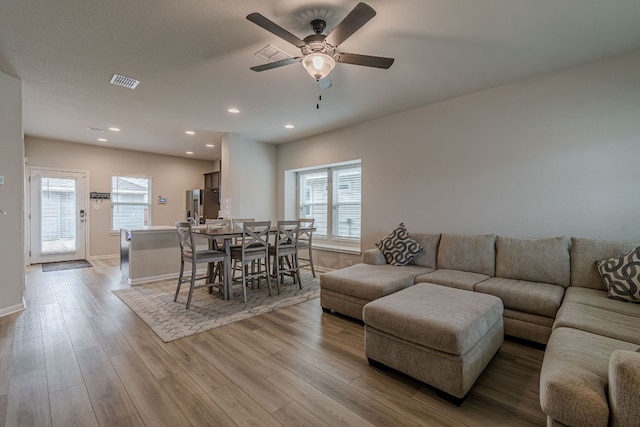 living area featuring ceiling fan, recessed lighting, visible vents, baseboards, and light wood finished floors