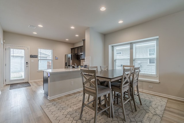 dining area featuring light wood finished floors, baseboards, visible vents, and recessed lighting