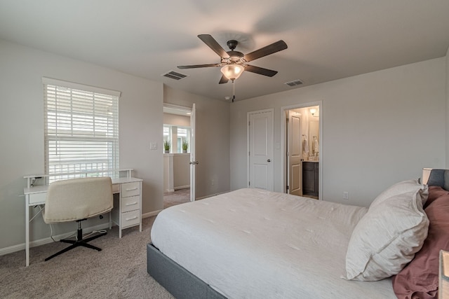 carpeted bedroom featuring ceiling fan, ensuite bath, visible vents, and baseboards