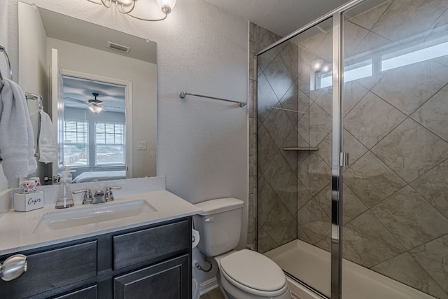 bathroom featuring tiled shower, a textured wall, toilet, ensuite bathroom, and vanity