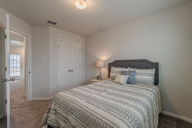 carpeted bedroom featuring a closet, visible vents, and baseboards