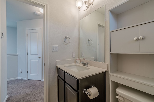 bathroom with toilet, baseboards, and vanity