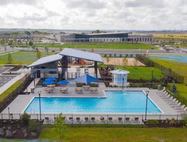 pool with a patio area, fence, and a lawn