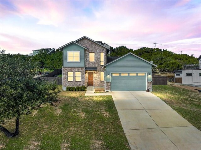 view of front of house featuring a garage and a lawn