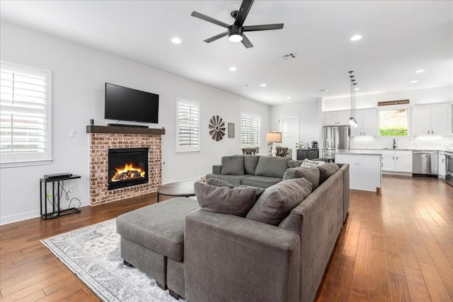 living area featuring ceiling fan, recessed lighting, a fireplace, wood finished floors, and visible vents